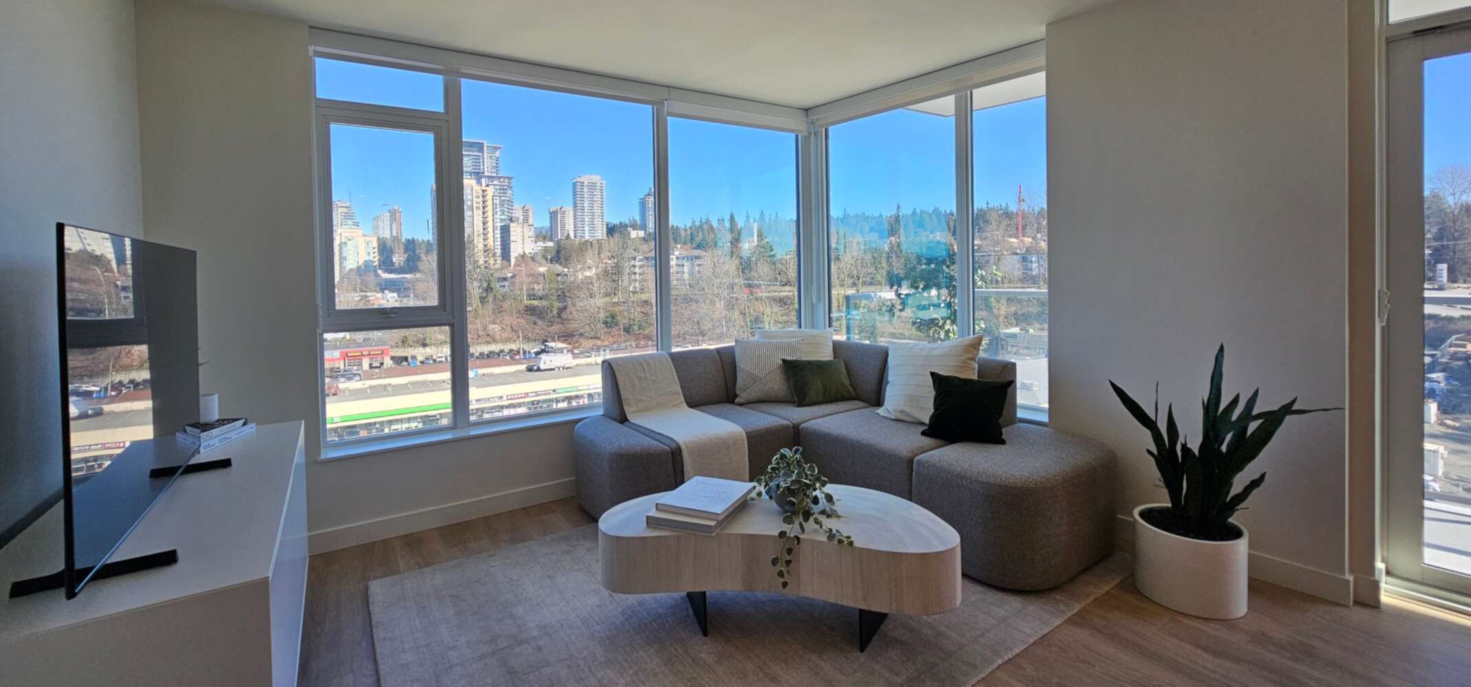 A living room in a Greater Vancouver high-rise, looking out over the city toward the North Shore